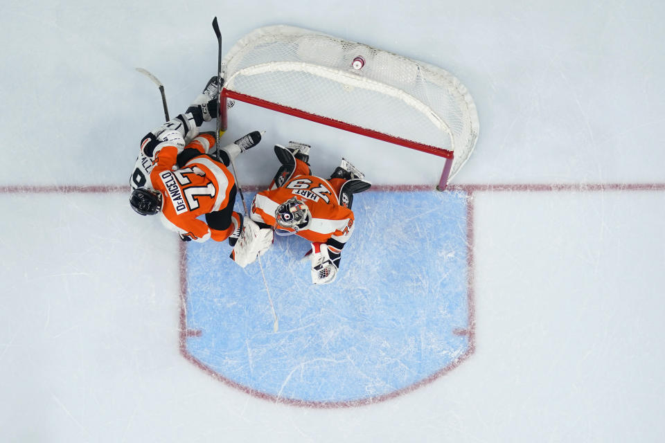 Los Angeles Kings' Alex Iafallo, left, collides with Philadelphia Flyers' Tony DeAngelo, center, and Carter Hart during the third period of an NHL hockey game, Tuesday, Jan. 24, 2023, in Philadelphia. (AP Photo/Matt Slocum)