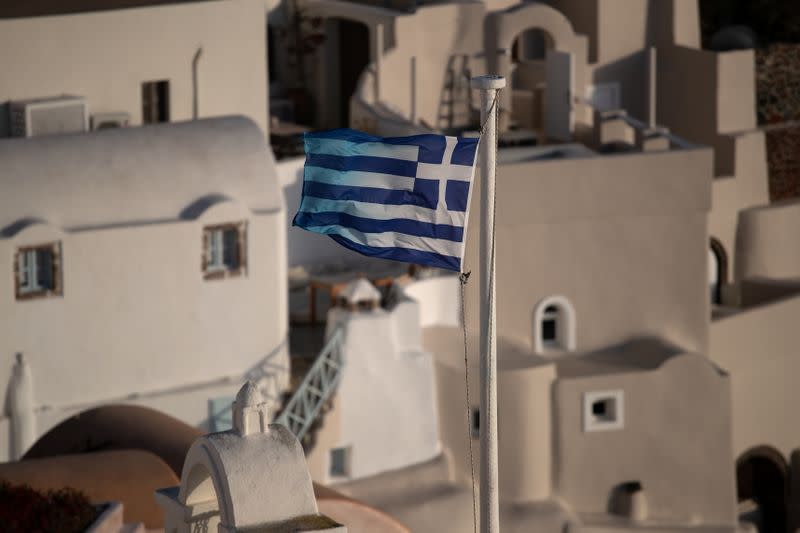 Una bandera nacional griega ondea en Oia, luego del brote de la enfermedad del coronavirus (COVID-19), en la isla de Santorini