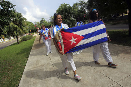 Recently released dissidents Haydee Gallardo (L) and Sonia Garro hold the Cuban national flag during a march in Havana January 11, 2015. REUTERS/Stringer