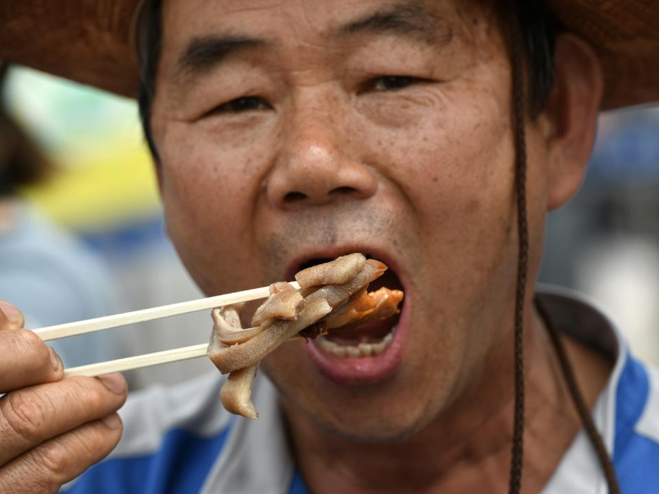 A South Korean dog farmer eats dog meat during an animal protest rally in Seoul, South Korea.