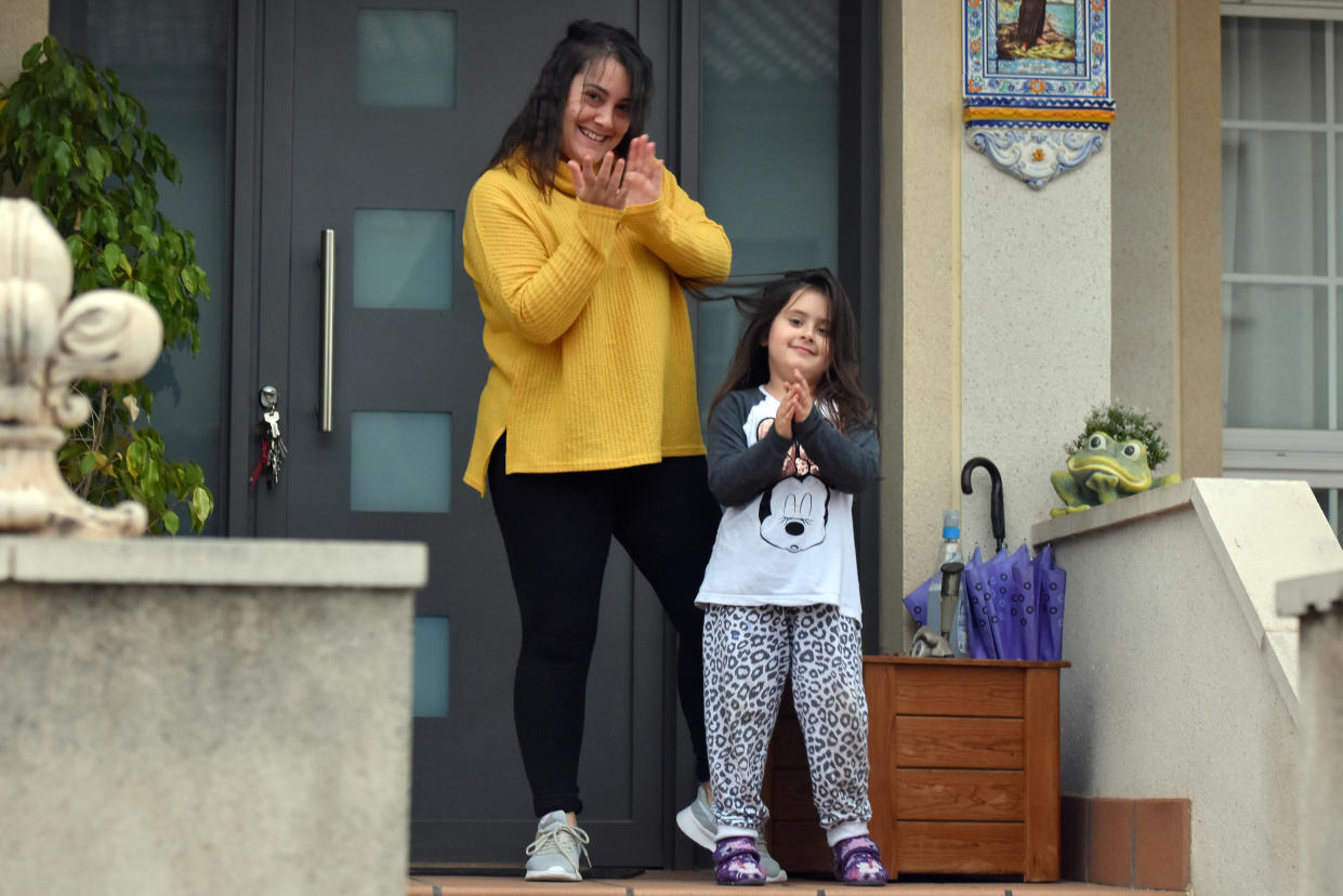 VENDRELL, SPAIN - 2020/04/19: A mother and her daughter applaud from their balcony to show gratitude to the Covid-19 fighters during confinement. Neighbours from El vendrell city (Tarragona) applaud to the Covid-19 fighters in gratitude and to cheer each other up from their balconies and gardens on the 37th day of confinement in Spain where the Government has extended the confinement period until 9 of May. (Photo by Ramon Costa/SOPA Images/LightRocket via Getty Images)