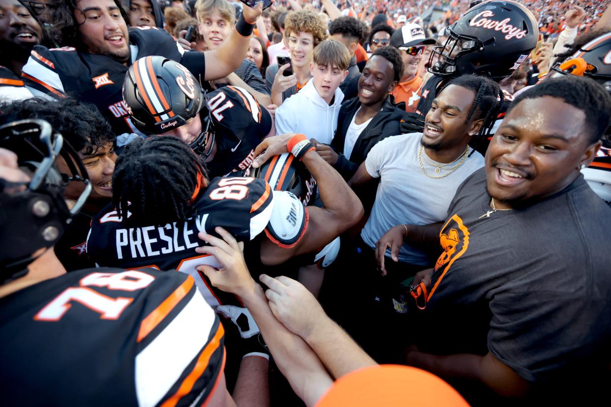 Oklahoma State players celebrate with fans at Stillwater's Boone Pickens Stadium after the Cowboys beat archrival Oklahoma 27-24 in the final game of the legendary Bedlam Series Saturday.