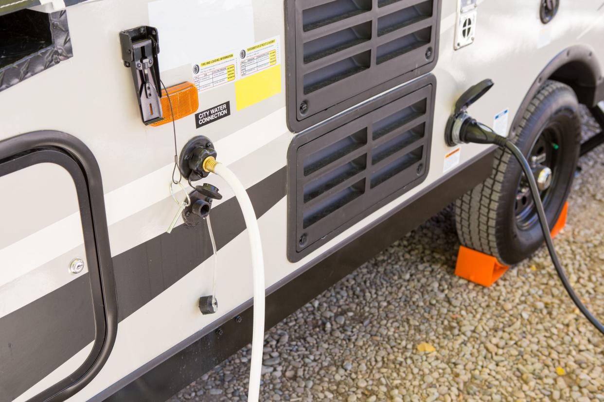 filling the water tank of a campervan in campground area