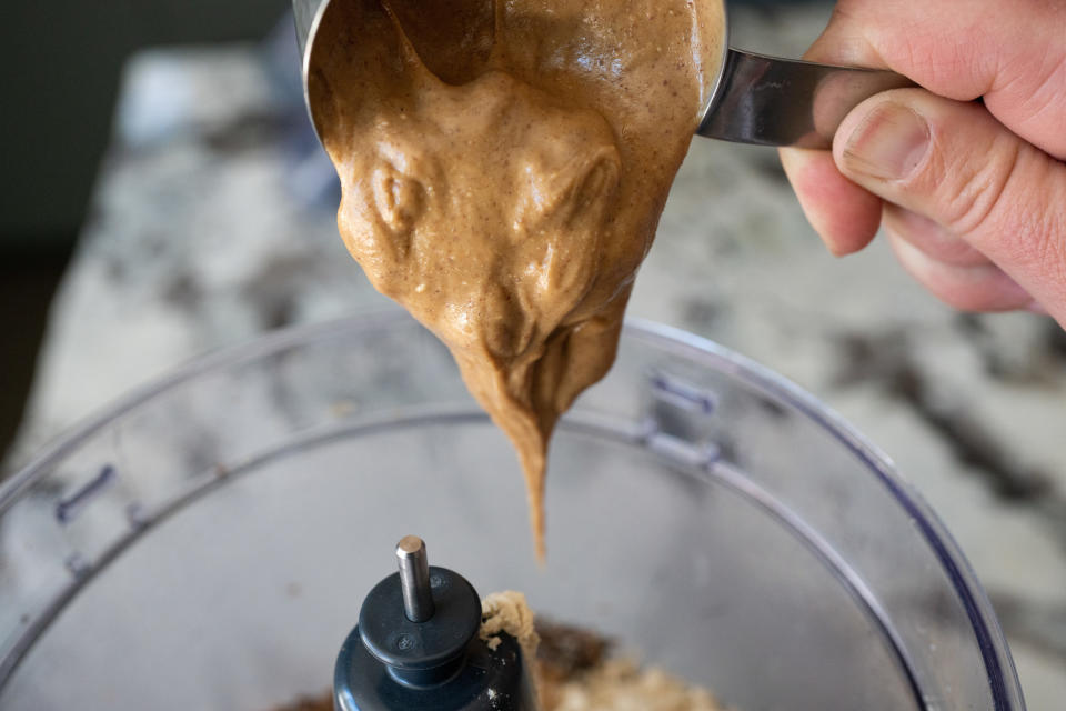 Peanut butter being poured into a blender