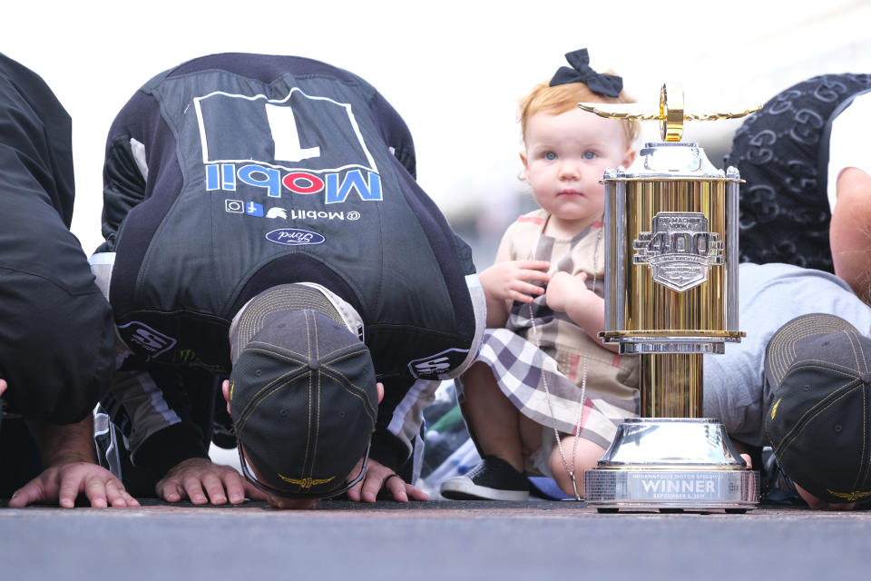FILE - Piper Harvick looks on as her father Kevin Harvick kisses the yard of bricks on the finish line after winning the NASCAR Brickyard 400 auto race at Indianapolis Motor Speedway, Sunday, Sept. 8, 2019, in Indianapolis. Kevin Harvick said Thursday, Jan. 12, 2023, he will retire from NASCAR competition at the end of the 2023 season. (AP Photo/AJ Mast, File)