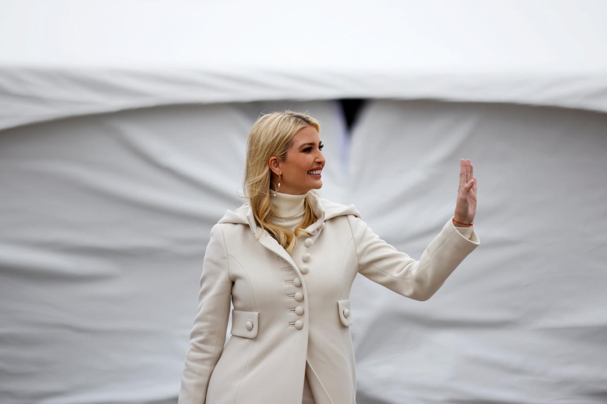 Ivanka Trump, in all white, waves as she arrives for a campaign rally.