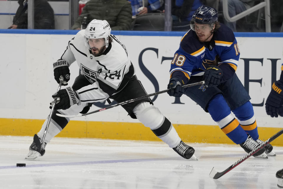 Los Angeles Kings' Phillip Danault (24) and St. Louis Blues' Robert Thomas (18) battle for a loose puck during the third period of an NHL hockey game Monday, Oct. 31, 2022, in St. Louis. (AP Photo/Jeff Roberson)