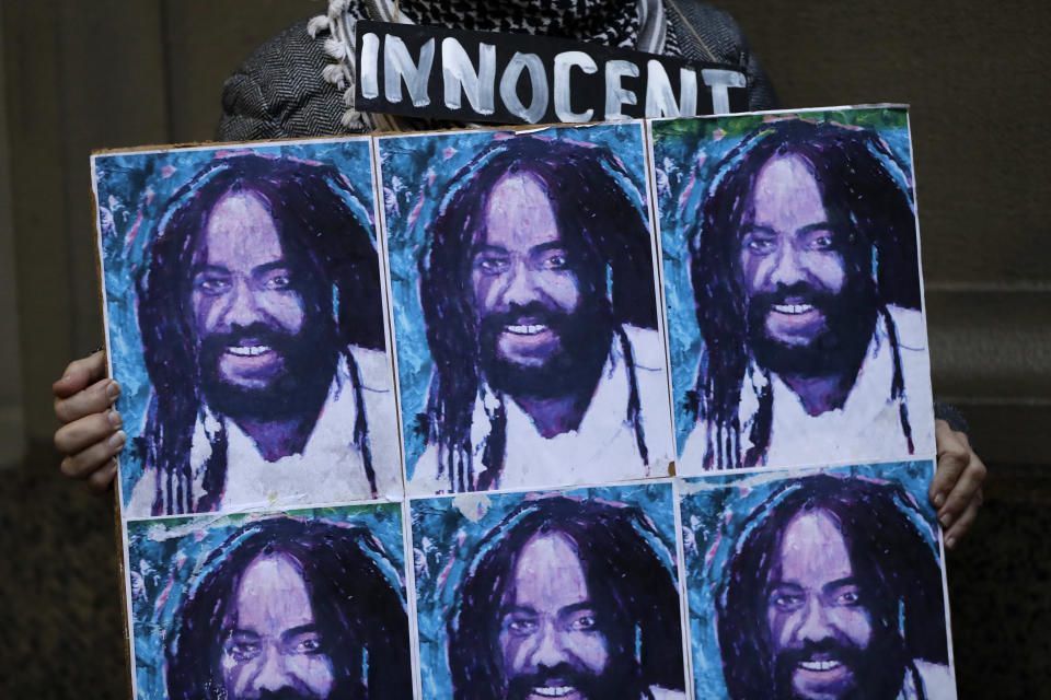 A protestor holds up a poster depicting Mumia Abu-Jamal during a demonstration outside the offices of District Attorney Larry Krasner, Friday, Dec. 28, 2018, in Philadelphia. A judge issued a split ruling Thursday that grants Abu-Jamal another chance to appeal his 1981 conviction in a Philadelphia police officer's death. (AP Photo/Matt Slocum)