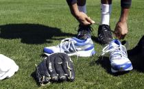 Retired NBA All-Star Tracy McGrady trades his tennis shoes for cleats before a workout at the Sugar Land Skeeters baseball stadium Wednesday, Feb. 12, 2014, in Sugar Land, Texas. McGrady hopes to tryout as a pitcher for the independent Atlantic League Skeeters. (AP Photo/Pat Sullivan)