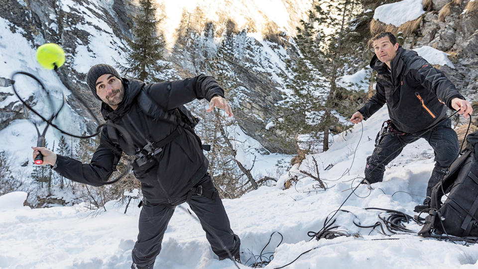 Roger Federer hitting the ball in the snow with Bear Grylls.