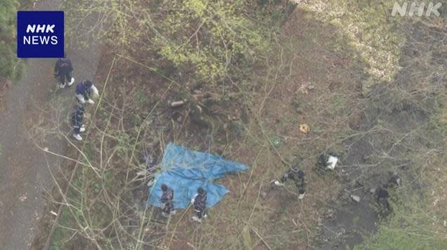 警方以藍布覆蓋2具焦屍，持續在現場搜證。(互聯網)