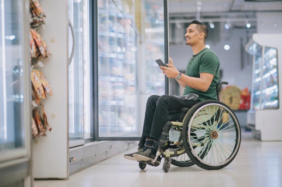 Man in wheelchair shopping at supermarket