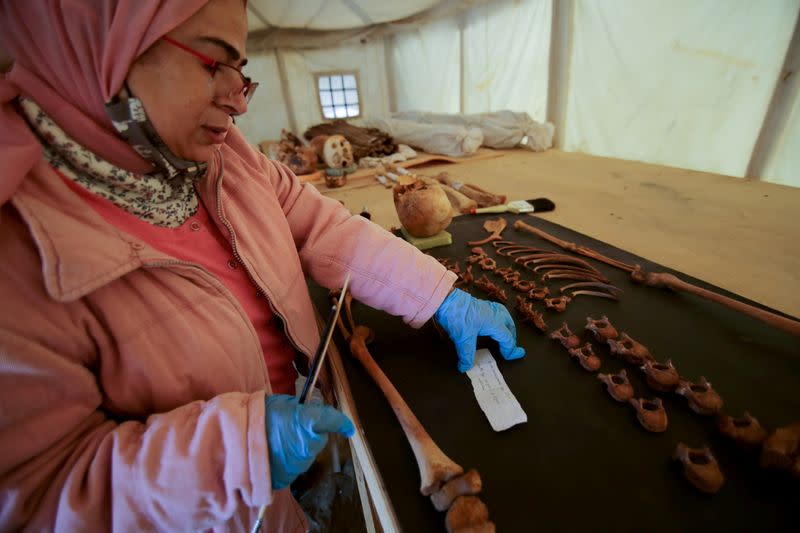 A woman works on artefacts, part of a recent discovery, at the Saqqara necropolis south of Cairo