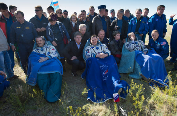 Expedition 35 Commander Chris Hadfield of the Canadian Space Agency (CSA), left, Russian Flight Engineer Roman Romanenko of the Russian Federal Space Agency (Roscosmos), center, and NASA Flight Engineer Tom Marshburn sit in chairs outside the S