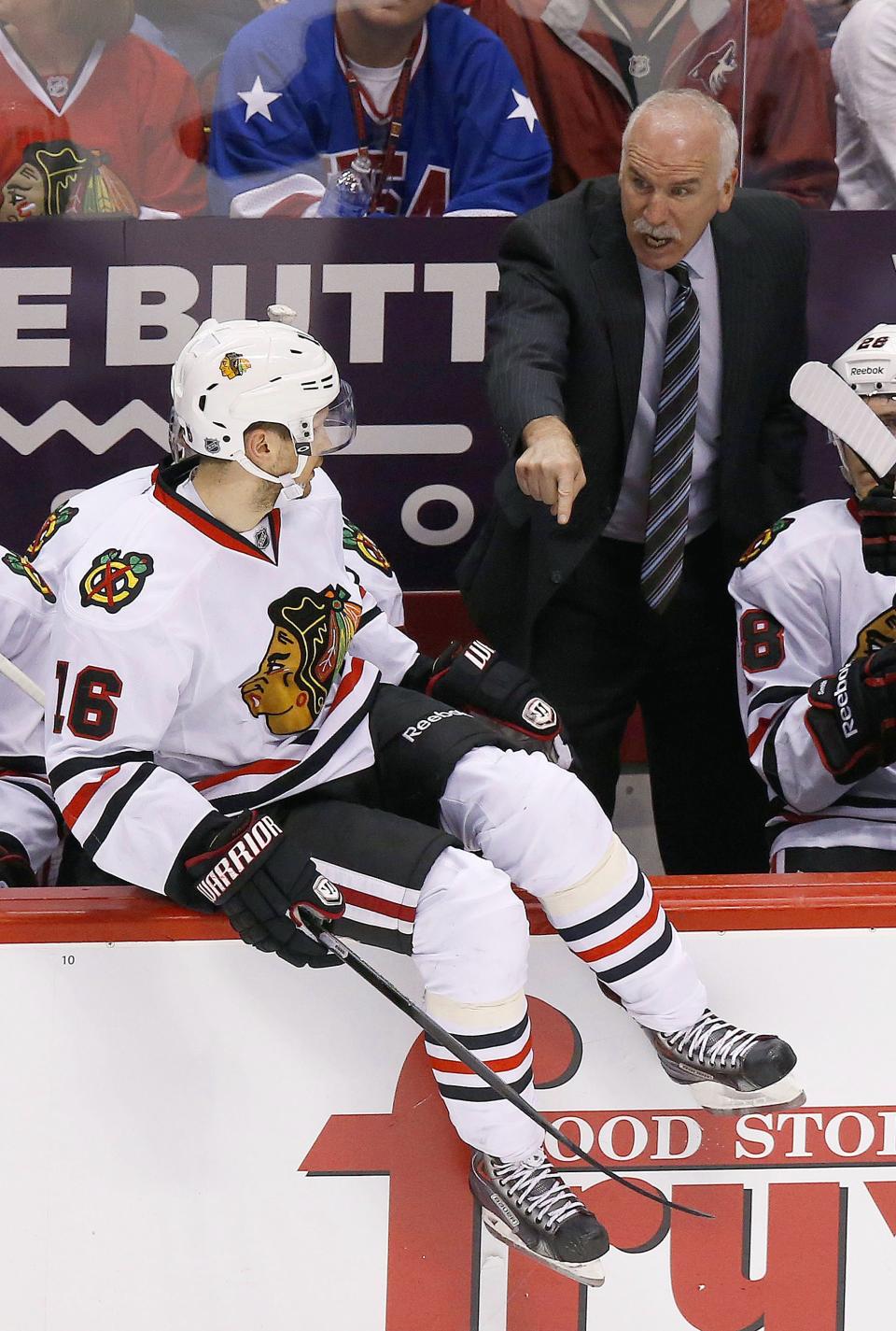Chicago Blackhawks' Joel Quenneville shouts instructions to his players, including Marcus Kruger (16), of Sweden, during the second period in an NHL hockey game against the Phoenix Coyotes, Friday Feb. 7, 2014, in Glendale, Ariz. (AP Photo/Ross D. Franklin)