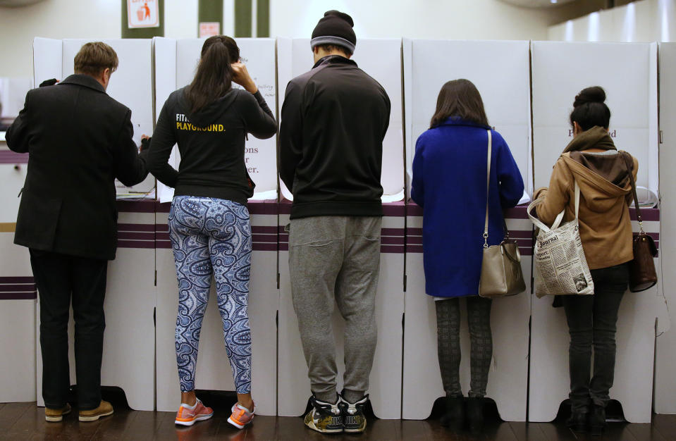 Voters fill in their ballots at a polling station at Town Hall