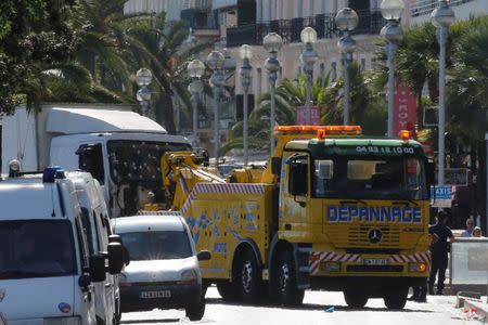 A tow truck removes the heavy truck with its windscreen covered with bullet impacts that ran into a crowd at high speed killing scores who were celebrating the Bastille Day July 14 national holiday on the Promenade des Anglais in Nice, France, July 15, 2016. REUTERS/Pascal Rossignol