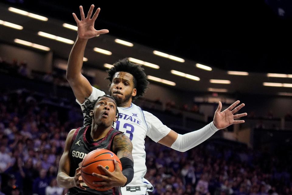 Oklahoma guard Javian McCollum, front, looks to shoot under pressure from Kansas State forward Will McNair Jr. (13) during the first half of an NCAA college basketball game Tuesday, Jan. 30, 2024, in Manhattan, Kan. (AP Photo/Charlie Riedel) ORG XMIT: KSCR111