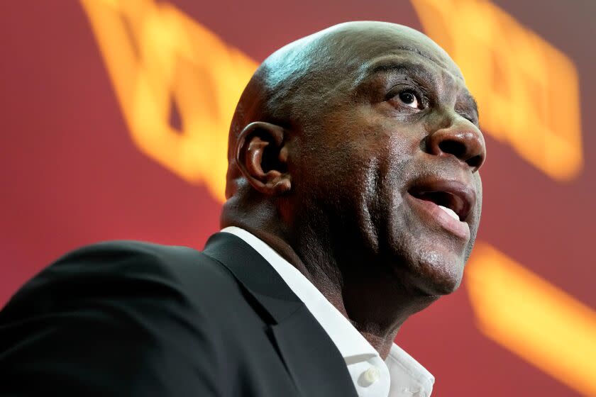 Magic Johnson, a member of the group buying the Washington Commanders, speaks at news conference at FedEx Field