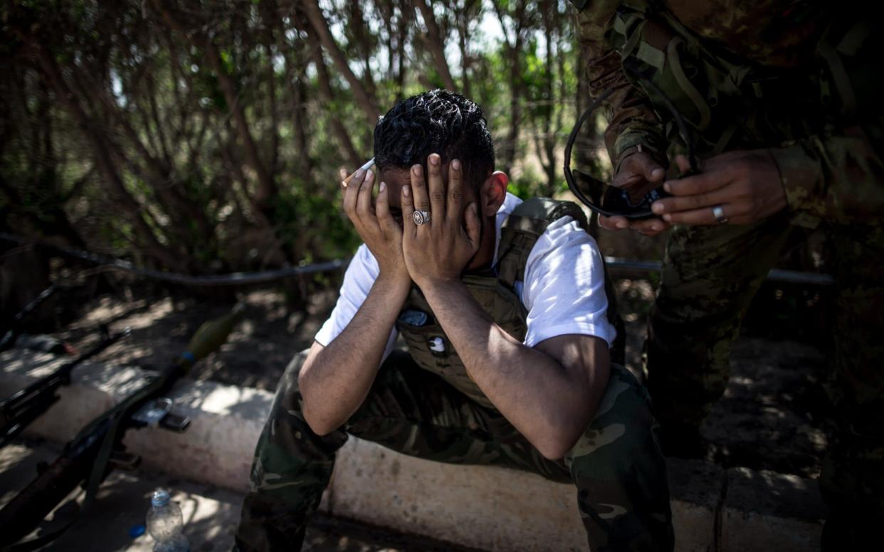 A fighter from forces of the UN-backed Libyan government reacts after one of his comrades was killed during clashes with the Libyan National Army (LNA) troops near Tripoli airport. - Xinhua / Barcroft Media