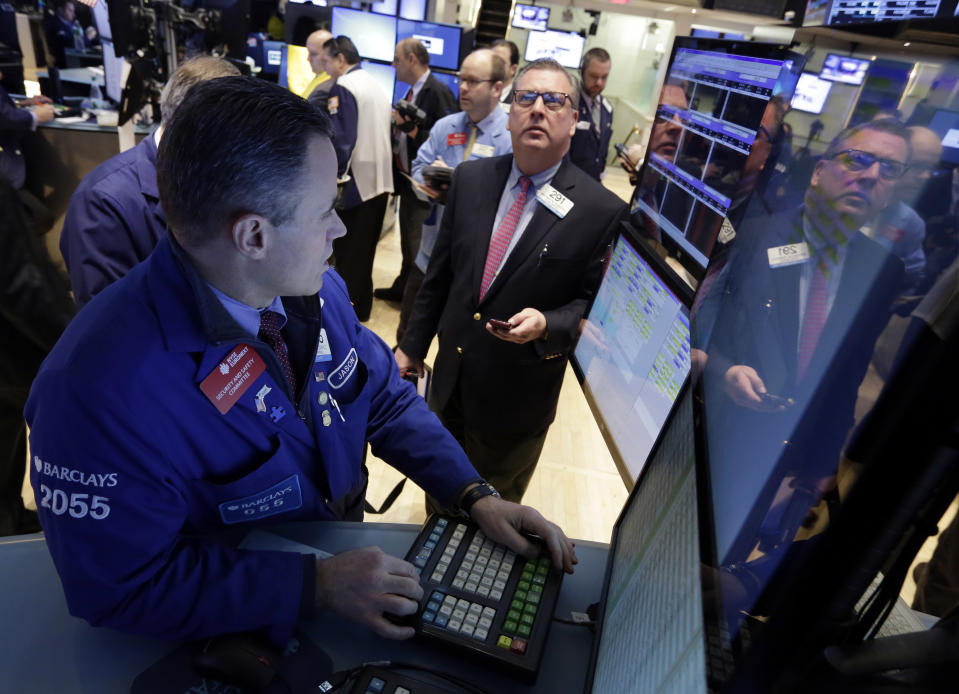 Jason Hardzewicz, left, works at his post on the floor of the New York Stock Exchange, Monday, Jan. 27, 2014. Stocks are mostly higher on Wall Street as investors shrug off worries about emerging markets that tanked the market last week. (AP Photo/Richard Drew)