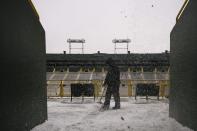 Snow is dropped from above as a paid volunteer clears snow from the bleachers at Lambeau Field in Green Bay, Wisconsin, the home field of the Green Bay Packers of the National Football League (NFL), December 21, 2013. In winter months, the team calls on the help of hundreds of citizens, who also get paid a $10 per-hour wage, to shovel snow and ice from the seating area ahead of games, local media reported. The Packers will host the Pittsburgh Steelers on Sunday, December 22. REUTERS/Mark Kauzlarich (UNITED STATES - Tags: ENVIRONMENT SPORT FOOTBALL)