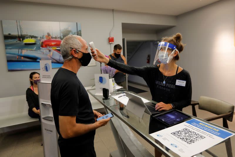 FILE PHOTO: Member gets temperature check at Chelsea Piers Fitness, Manhattan's largest fitness facility on first day of re-opening of gyms in New York