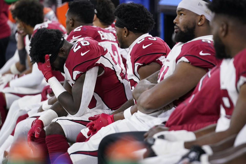 Arizona Cardinals running back Eno Benjamin, left, sits on the bench with teammates during the second half of an NFL wild-card playoff football game against the Los Angeles Rams in Inglewood, Calif., Monday, Jan. 17, 2022. (AP Photo/Jae C. Hong)