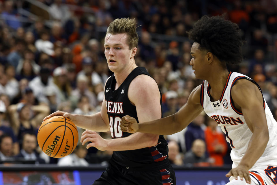 Penn guard George Smith (40) dribbles around Auburn guard Aden Holloway (1) during the first half of an NCAA college basketball game Tuesday, Jan. 2, 2024, in Auburn, Ala. (AP Photo/Butch Dill)