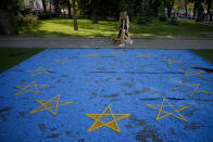 FILE - Girls walk by a EU flag installation in a park in Chisinau, Moldova, Wednesday, May 31, 2023. Ukraine is set to officially launch membership talks with the European Union later on Tuesday, June 25, 2024. Moldova will also set its accession process in motion, as the EU hosts two intergovernmental conferences in Luxembourg. (AP Photo/Andreea Alexandru, File)