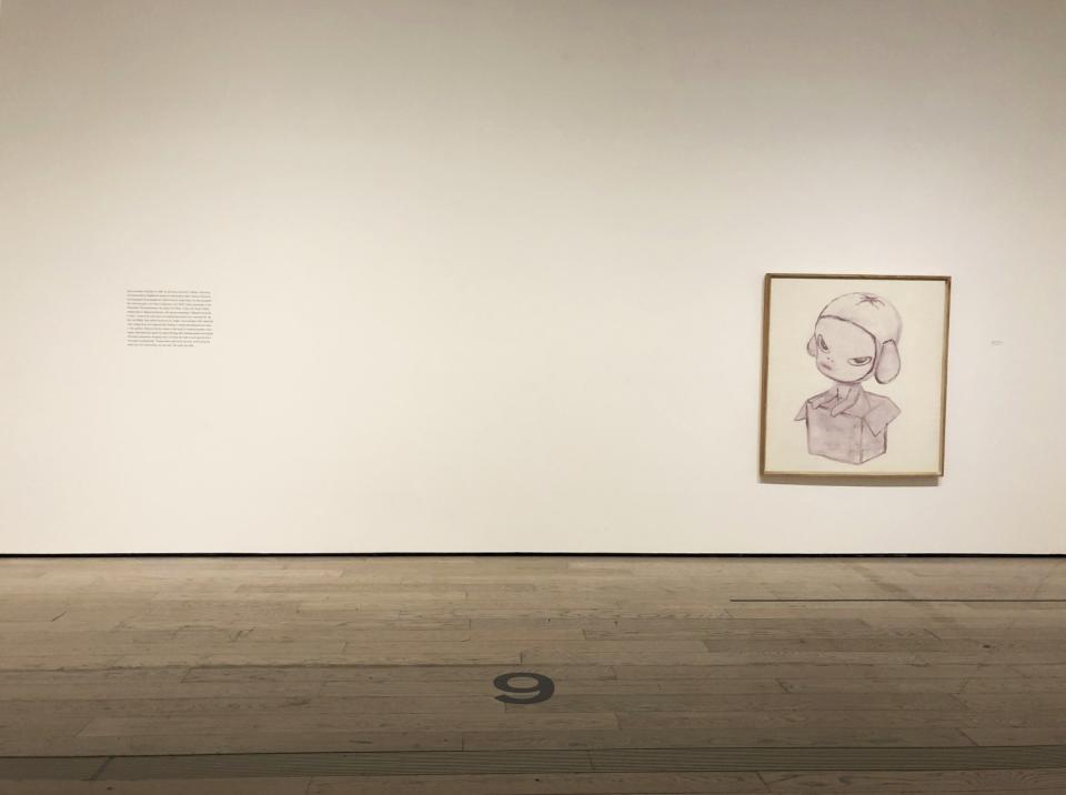 A piece of wall text is located several feet from a painting at LACMA gallery.