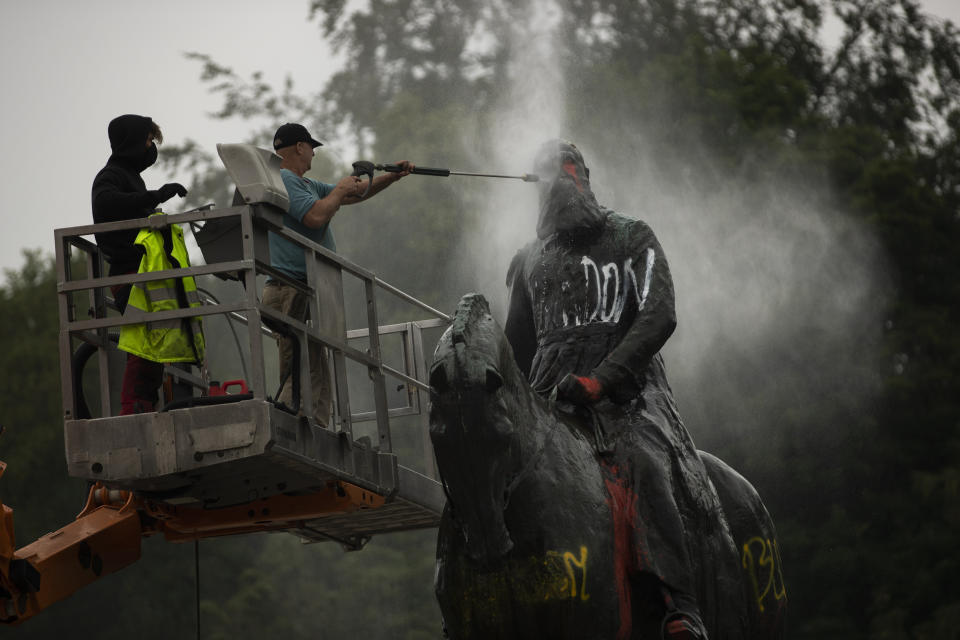 FILE - In this file photo dated Thursday, June 11, 2020 workers clean graffiti from a statue of Belgium's King Leopold II in Brussels, that was targeted by protesters during a Black Lives Matter demonstration. Leopold is increasingly seen as a stain on the nation where he reigned from 1865 to 1909. The death of George Floyd at the hands of police and Minneapolis, USA, has sparked a re-examination of injustices and inequalities in the fabric of many societies, often symbolized in statues of historical figures have become the focus of protest around the world. (AP Photo/Francisco Seco, FILE)