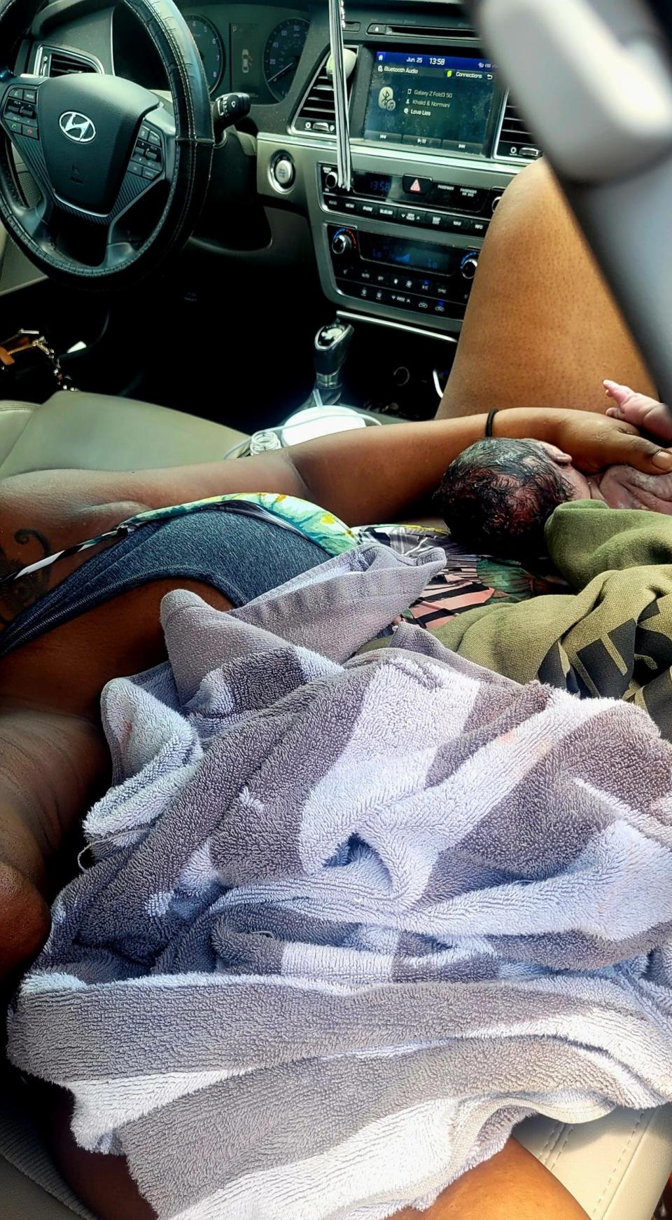 Isis Davis of Palm Coast holds her newborn son, Akovi Davis, after giving birth to him roadside near the intersection of U.S. 1 and State Road 206 near St. Augustine, Sunday, June 25, 2023.