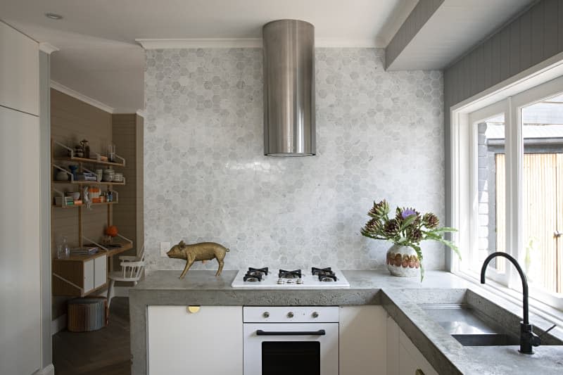 an industrial style kitchen with a gray and white hexagonal backsplash