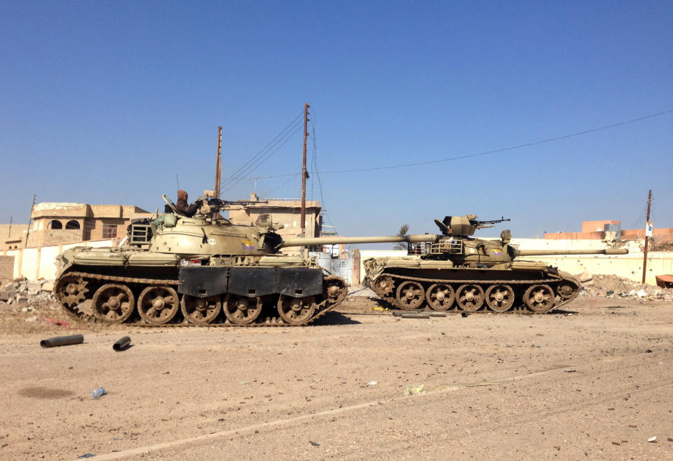 In this picture taken on Thursday, Feb. 6, 2014, Iraqi tanks patrol after clashes with al-Qaida fighters at Malaab district, which Iraqi troops recaptured recently, in Ramadi, 70 miles (115 kilometers) west of Baghdad, Iraq. Al-Qaida-led militants are battling for control of mainly Sunni areas to the west of the Iraqi capital in a key test of the Shiite-led government's ability to maintain security in the country more than two years after the withdrawal of U.S. troops. (AP Photo)