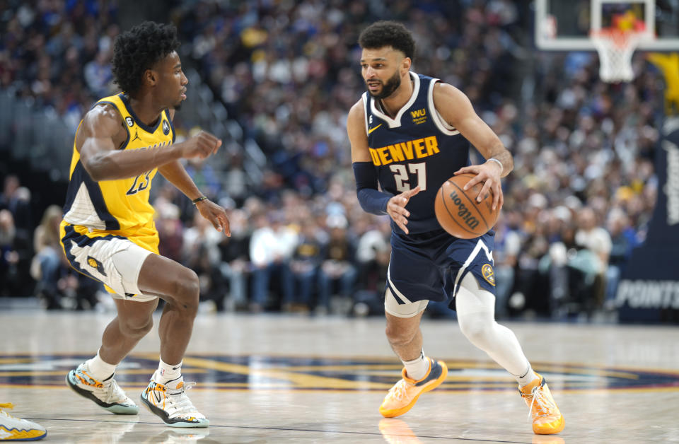 Denver Nuggets guard Jamal Murray, right, is defended by Indiana Pacers forward Aaron Nesmith during the second half of an NBA basketball game Friday, Jan. 20, 2023, in Denver. (AP Photo/David Zalubowski)