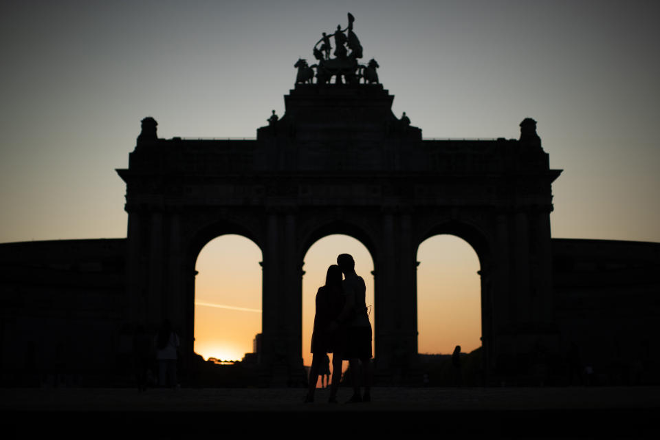 A couple hugs next to the triumphal arch at the Cinquantenaire Park during a partial lockdown to prevent the spread of Covid-19 in Brussels, Saturday, April 11, 2020. The new coronavirus causes mild or moderate symptoms for most people, but for some, especially older adults and people with existing health problems, it can cause more severe illness or death. (AP Photo/Francisco Seco)