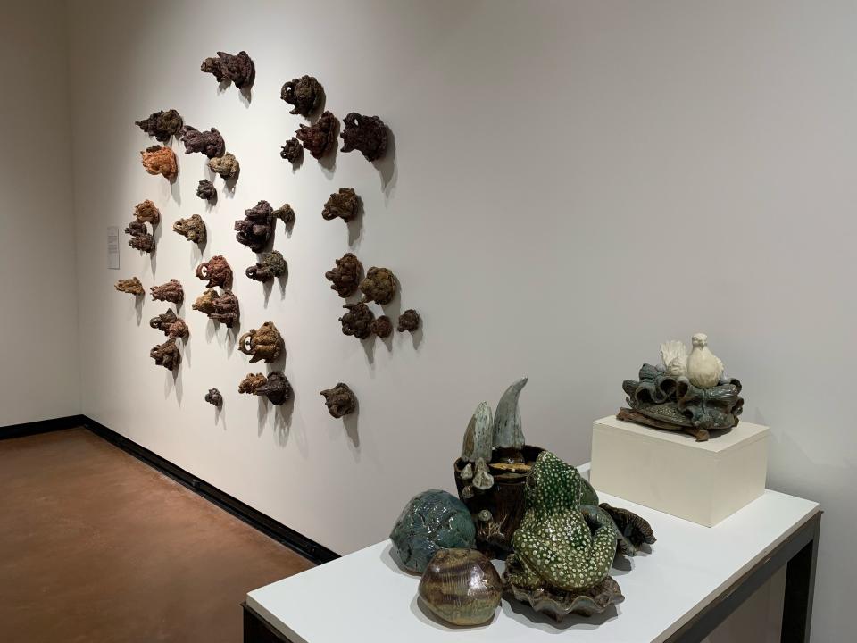 Ceramic pieces by Steve Hilton on the wall and Pamela Moller are seen at the MSU Texas faculty show.