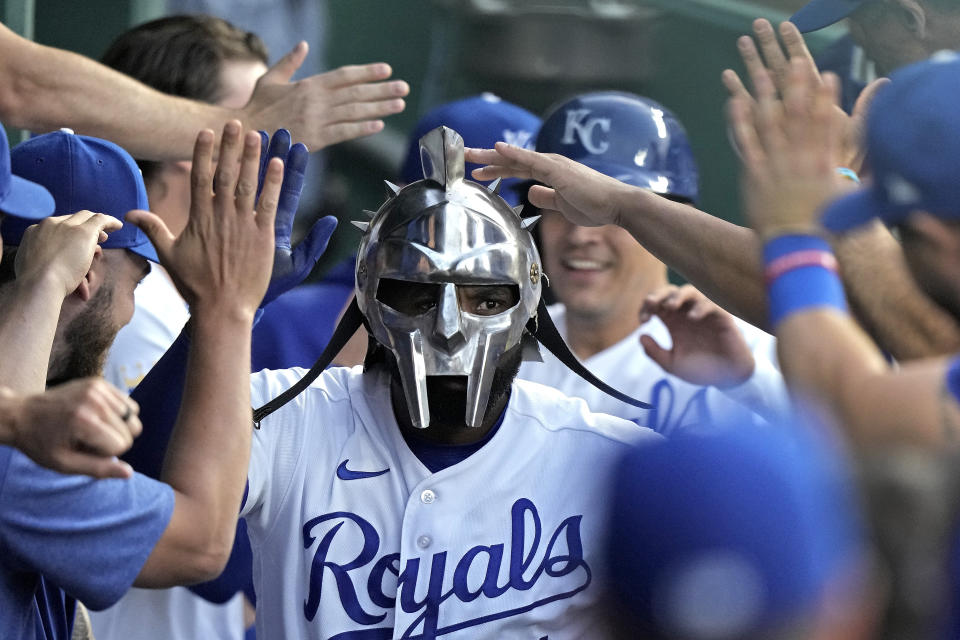 FILE - Kansas City Royals' Jackie Bradley Jr., wearing a gladiator style helmet, is greeted in the dugout after hitting a two-run home run against the Detroit Tigers Monday, May 22, 2023, in Kansas City, Mo. About half the clubs in MLB are using some kind of prop or ritual to celebrate a big hit or a big play in ways that often go viral. (AP Photo/Charlie Riedel, File)