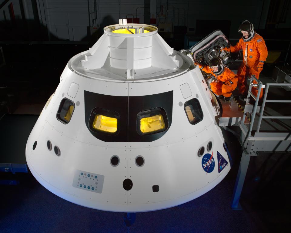 NASA astronauts step into the Orion crew module hatch during a series of spacesuit check tests conducted on June 13, 2013.