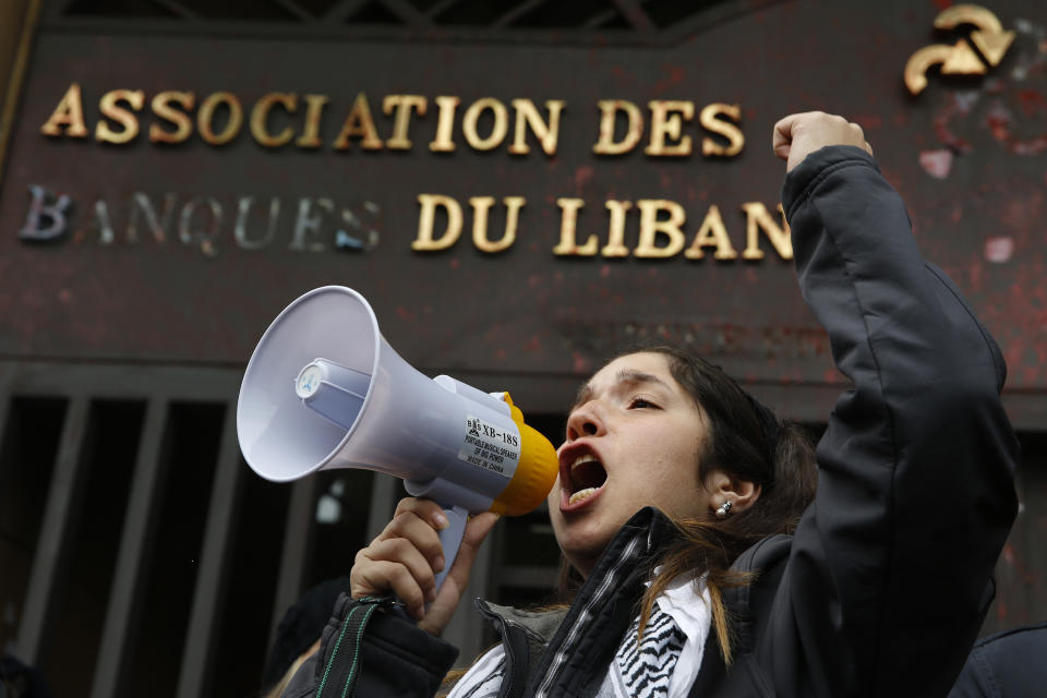 A protester leads a chant during ongoing protests against the Lebanese political class, in front of the building of the Lebanese Association of Banks in Beirut, Lebanon, Thursday, Dec. 26, 2019. (AP Photo/Bilal Hussein)