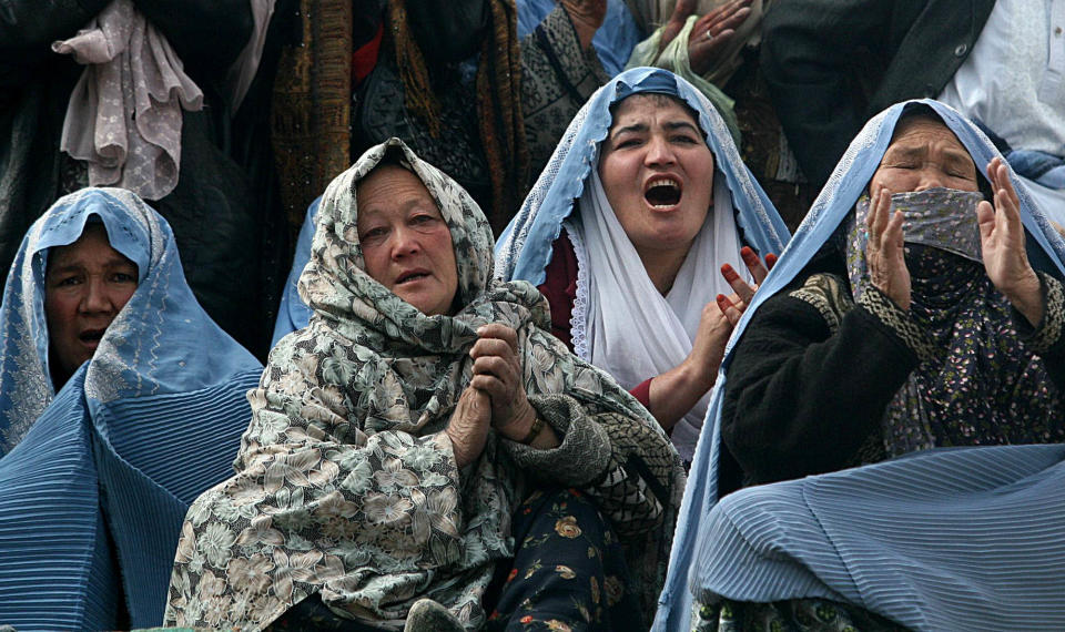 FILE - In this Wednesday, March 21, 2007 file photo, Afghan women pray as Afghan men hoist a holy mace, unseen, on the occasion of Nawroz, a new year ceremony, at the Sakhi Shrine in Kabul, Afghanistan. As the country braces for next year's presidential election and the planned withdrawal of most foreign combat troops by the end of 2014, the panel urges the U.S. government and its allies to work harder to promote religious rights in the war-torn nation. (AP Photo/Rafiq Maqbool, File)