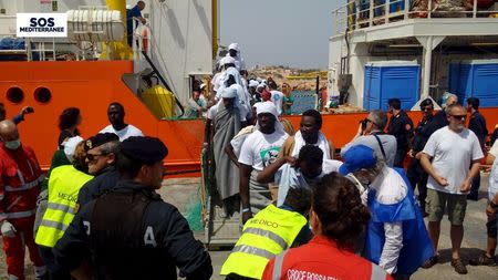 Migrants disembark from the SOS Mediterranee ship Aquarius at the Italian island of Lampedusa in this April 18, 2016. REUTERS/Sos Mediterranee/handout