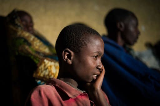 A displaced Congolese boy from Bihumba sits with his family outside a primary school being used for shelter in the village of Kibati on the outskirts of Goma in the Democratic Republic of the Congo's restive North Kivu province. United Nations helicopters fired on rebel positions in eastern Democratic Republic of Congo after new clashes broke out between rebel fighters and loyalist troops