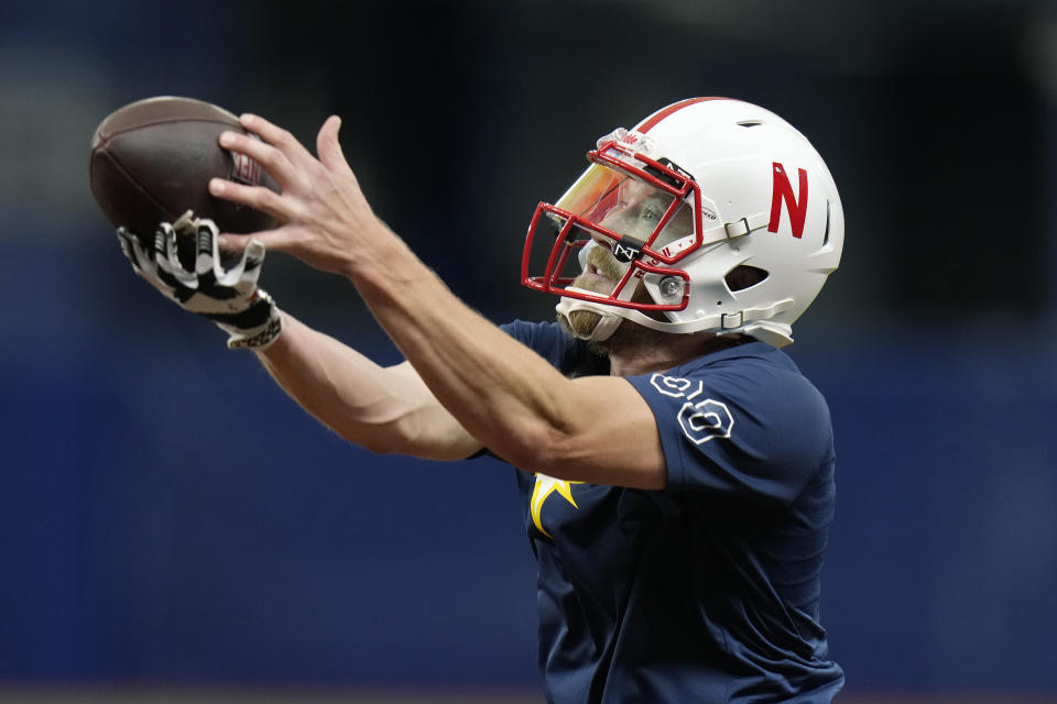 Tampa Bay Rays relief pitcher Jake Diekman dons a University of Nebraska football helmet as he catches the ball while warming up before a baseball game against the Los Angeles Angels Wednesday, Sept. 20, 2023, in St. Petersburg, Fla. Diekman was born in Wymore, Nebraska. (AP Photo/Chris O'Meara)