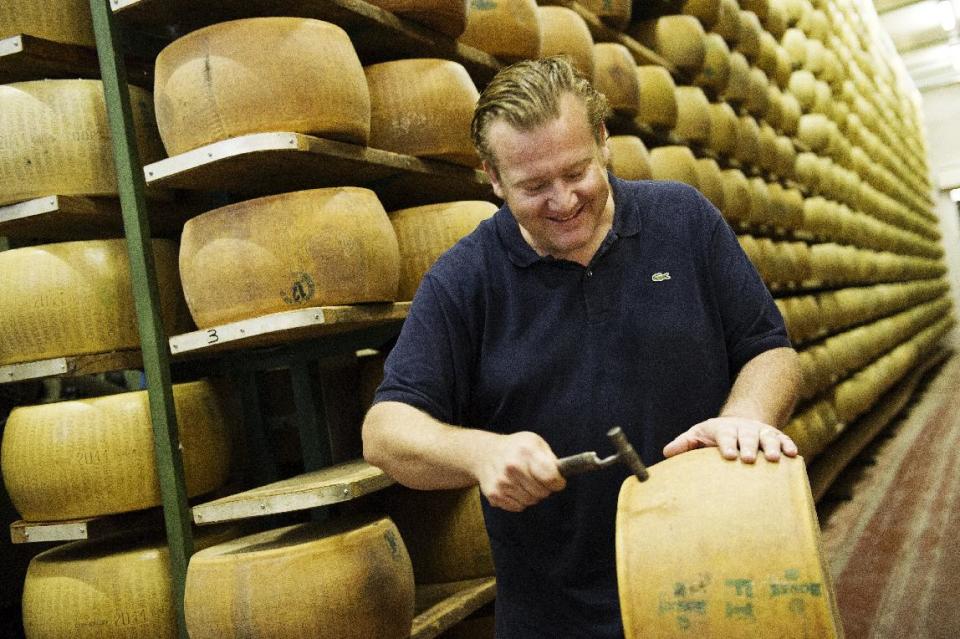 This book cover image released by Ballantine Books shows Michael White with a wheel of cheese to be used for a dish from his book "Classico E Moderno: Essential Italian Cooking," with Andrew Friedman. White is the chef and owner of Marea restaurant in New York. (AP Photo/Ballantine Books, Evan Sung)