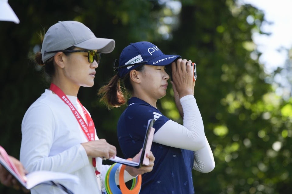 Hinako Shibuno, of Japan, right, measures the fifth hole during a practice round for the Women's PGA Championship golf tournament at Sahalee Country Club, Wednesday, June 19, 2024, in Sammamish, Wash. (AP Photo/Gerald Herbert)