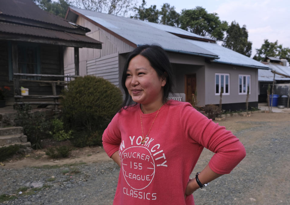 In this Sunday, March 22, 2020, photo, Ringhuila Zimik, 26, smiles as she speaks about the rumor of medicine being sprayed from the sky to contain a new virus, in Shangshak village, in the northeastern Indian state of Manipur. "We all heard about it. I didn't know whether to believe it or not but stayed indoors anyway," she said. As India and other South Asian nations brace for the likely spread of the virus, they are facing another battle: reams of misinformation, misleading rumors and false claims. This battle has been hard to contain as social media continues to be rife with bogus remedies to tales of magic cure and potentially dangerous medical advice. (AP Photo/Yirmiyan Arthur)