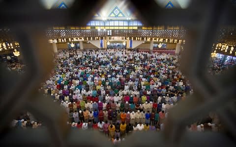 Muslims offer prayers during the first day of Eid al-Fitr, which marks the end of the holy fasting month of Ramadan in Kuala Lumpur, Malaysia last year - Credit: Vincent Thian/AP