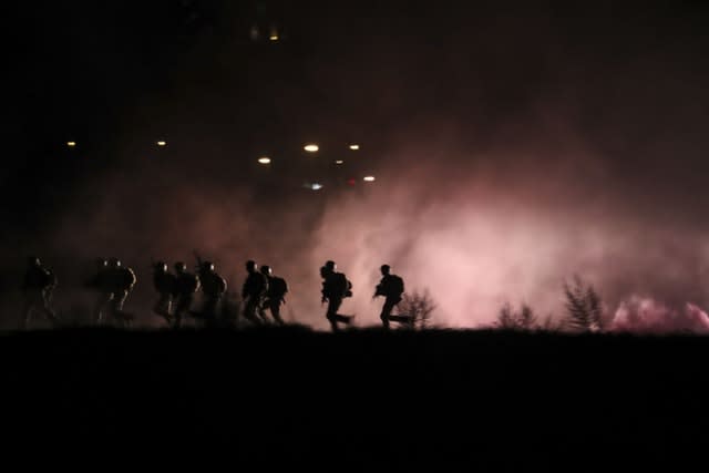 Soldiers running along the river bank